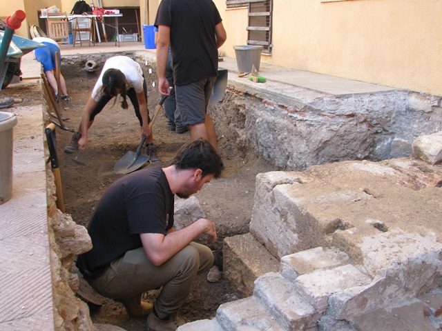 Intervenció arqueològica al pati del Museu Bíblic, amb la rasa que secciona el del mur de tancament dels porticats del recinte de culte imperial.