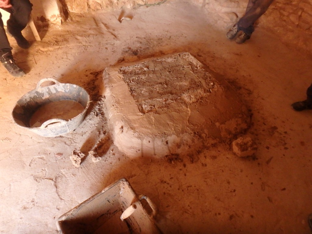 Imatge d’una llar construïda amb toves, en un espai interior, que queda sobreaixecada respecte del nivell de paviment. Està delimitada per una revora, i el conjunt està revestit de fang. Foto: projecte TRANSCOMB (ICAC).